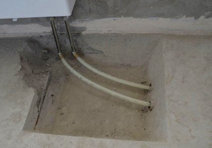 Os detalhes do sistema de aquecimento do coletor em uma casa particular Colocar juntas acima do nível do chão