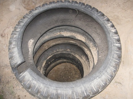 Tire pit for heated summer shower The wall is lined with used tires