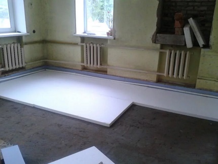 Pose de l'isolation de la dalle sur la fondation avant l'installation du chauffage au sol L'utilisation de mousse