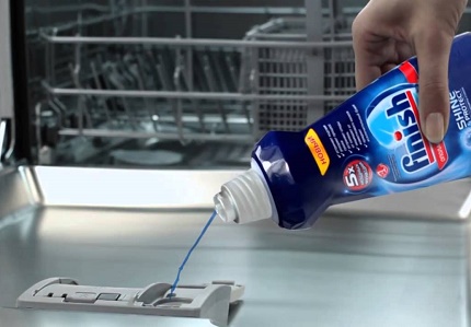 Le processus de verser du liquide de rinçage dans le lave-vaisselle Produit de rinçage au lave-vaisselle