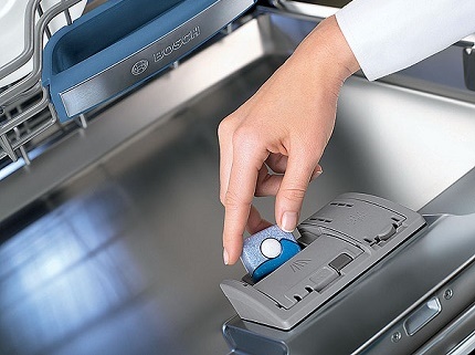 Chargement des comprimés dans une cuve de lave-vaisselle