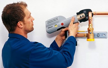 Der Meister kräuselt ein Kupferrohr